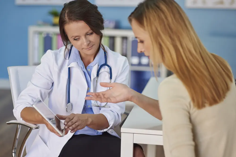 Médica explicando resultados de exames para uma paciente no consultório