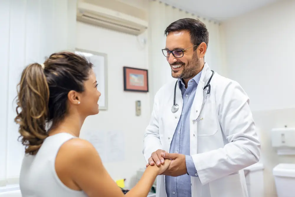 Médico em consultório ouvindo os sintomas relatados por uma paciente