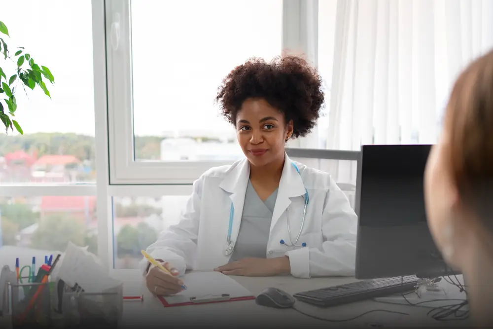 Nutricionista anotando o plano alimentar durante consulta no consultório da clínica