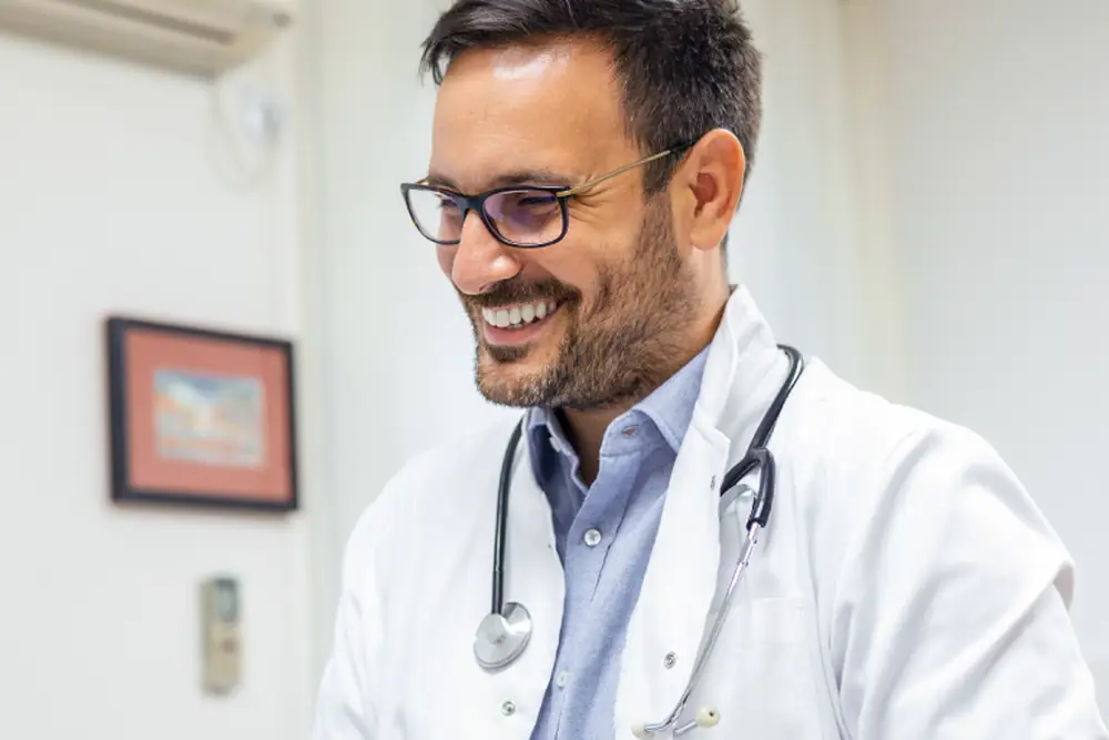 Profissional de saúde sorrindo durante atendimento no consultório da Clínica Higya